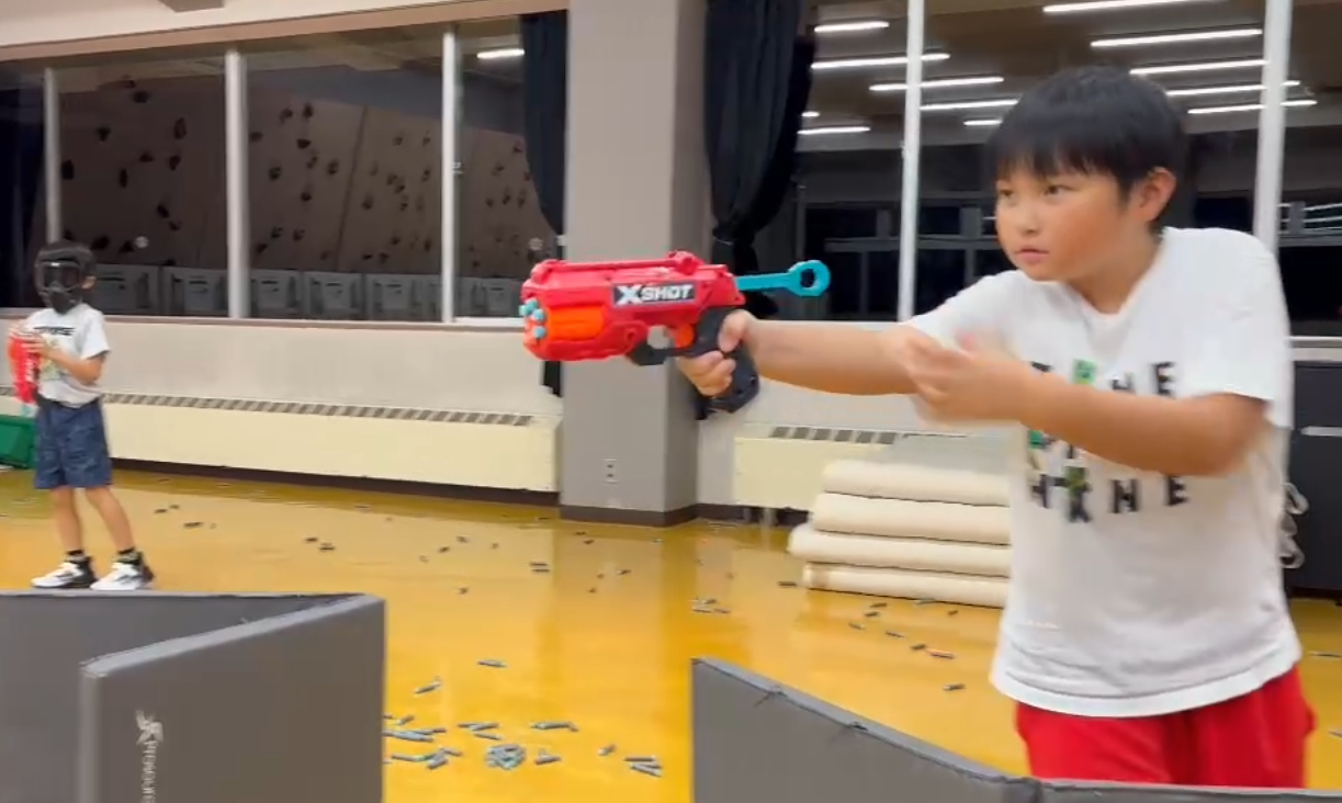 体育館でシューティングバトルを楽しむ子どもたち